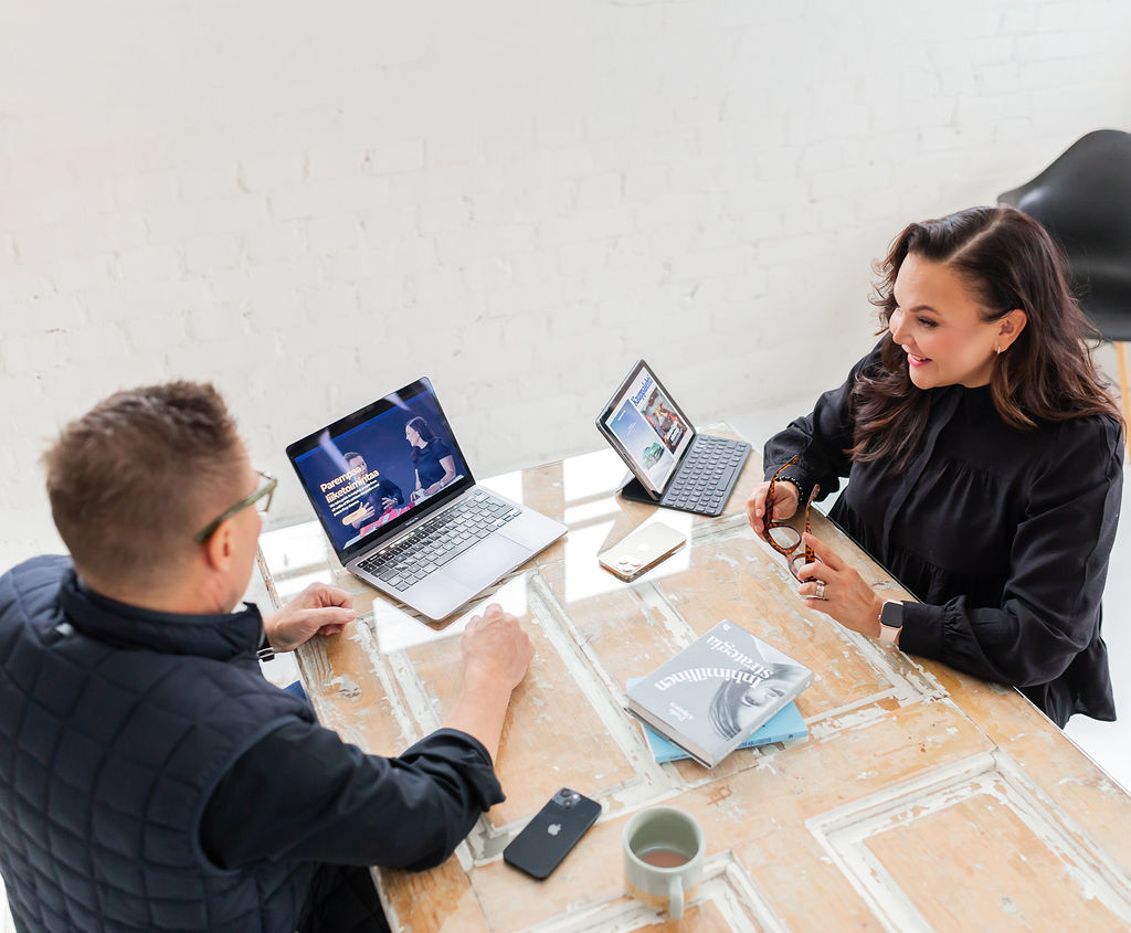 Kuvituskuva Marika ja Manu istumassa pöydän ääressä.